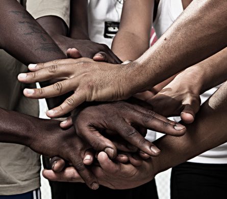 Closeup portrait of group with mixed race people with hands together